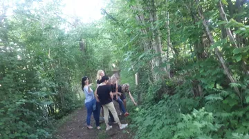 Group of people exploring forest trail.