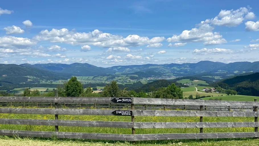 Wooden fence overlooks scenic mountain valley.
