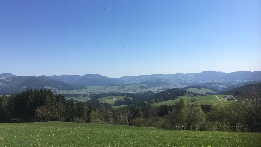 Hills and valleys under clear blue sky.