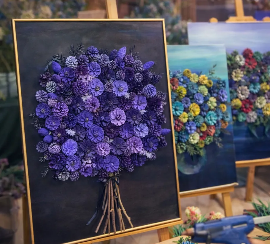 Colorful pinecone art displayed on easels.