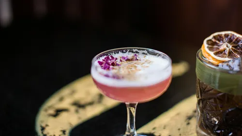 Bunte Cocktailgläser auf dunklem Tisch.