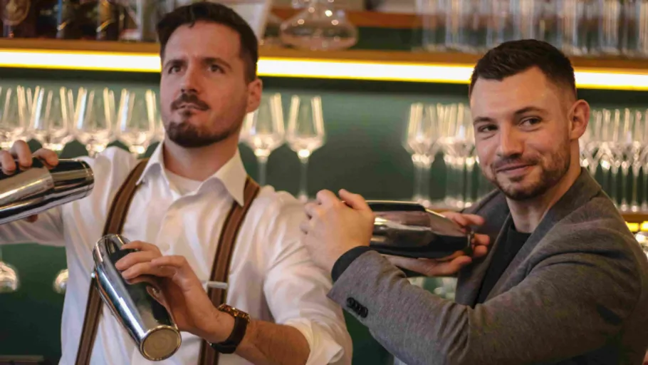 Zwei Barkeeper schütteln Cocktail-Shaker in Bar.