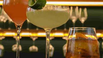 Drei Cocktails auf einer Bartheke.