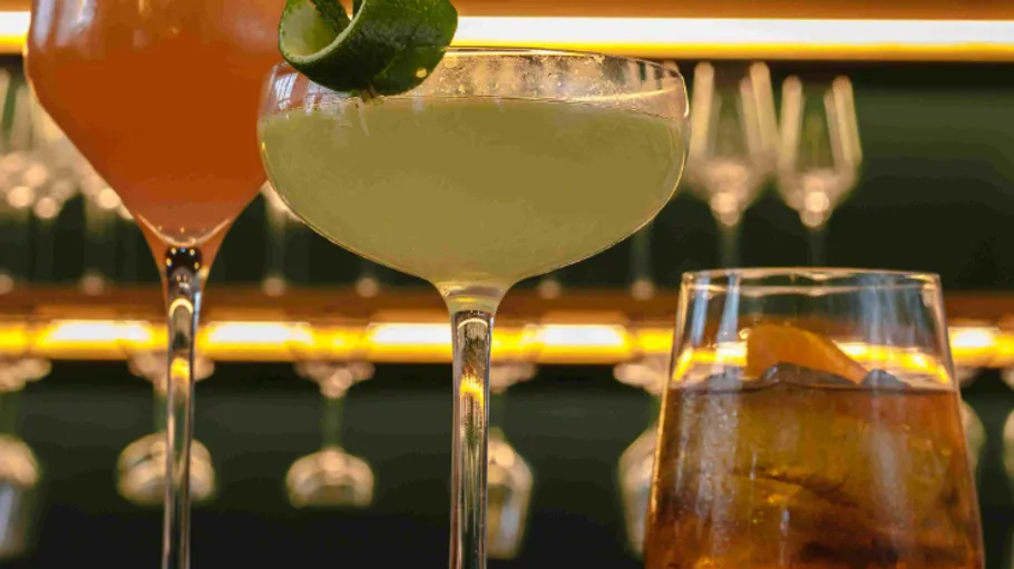 Drei Cocktails auf einer Bartheke.