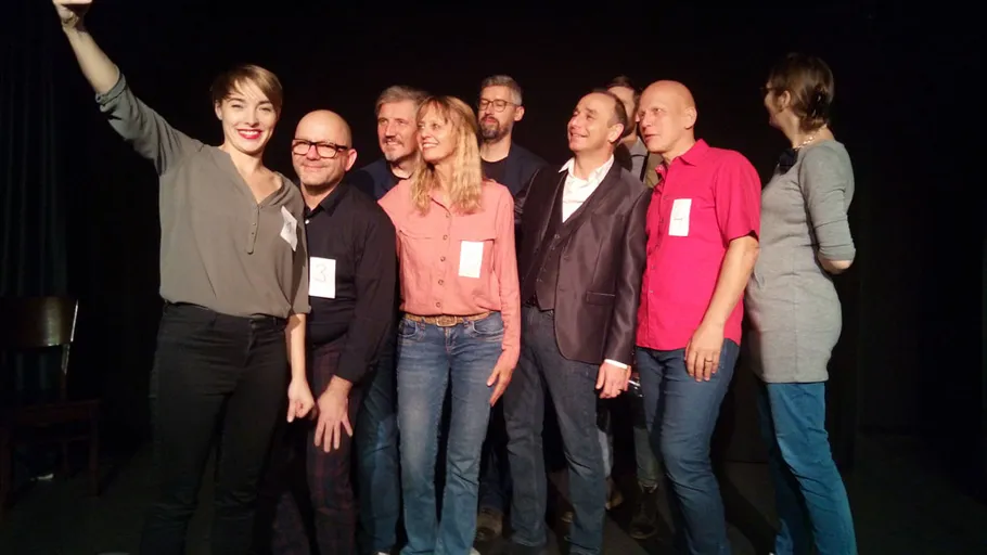 Gruppe macht Selfie auf Bühne mit Lächeln.