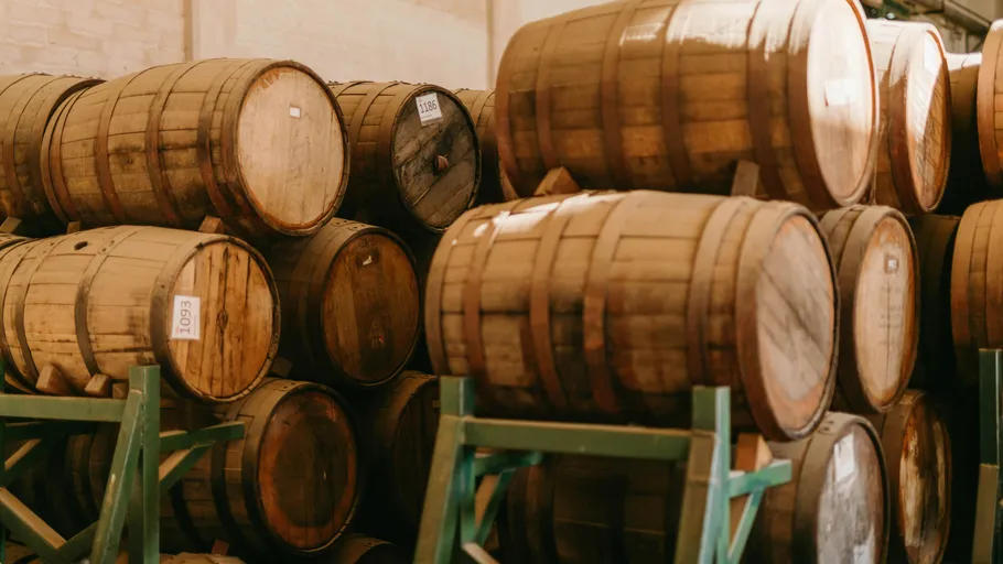 Wooden barrels stacked in a storage facility.
