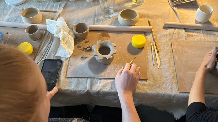 People sculpting clay at a pottery workshop.