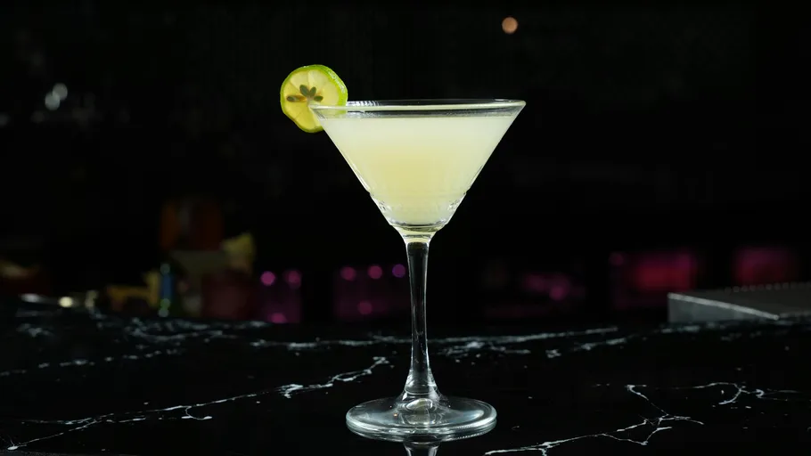 Cocktailglas mit Limettengarnitur, schwarzer Hintergrund.