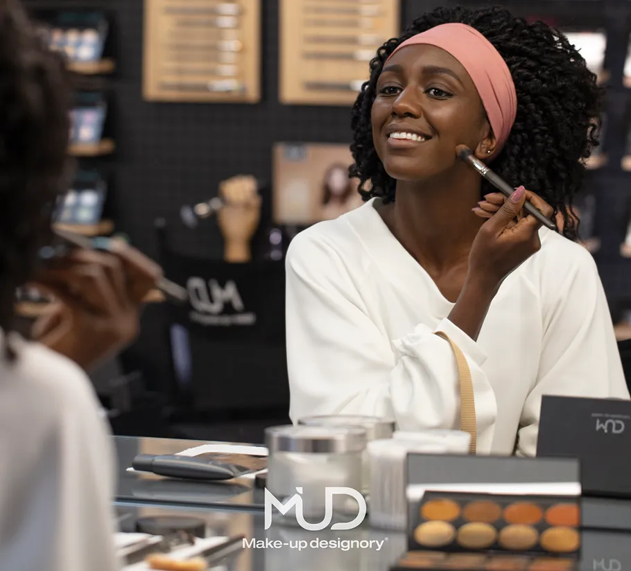Woman applying makeup in a store setting.