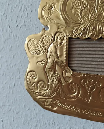 Verzierte goldene Plakette mit filigranen Designs.