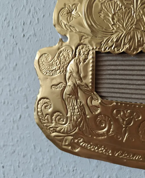 Verzierte goldene Plakette mit filigranen Designs.