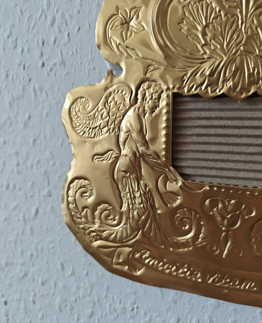 Verzierte goldene Plakette mit filigranen Designs.