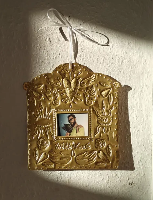 Goldener Rahmen mit Foto und geprägten Verzierungen.