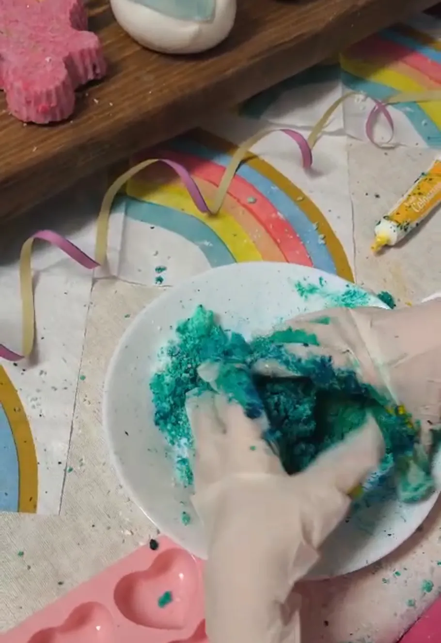 Gloved hands mixing blue powder in bowl.