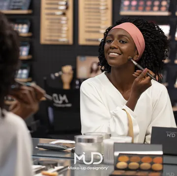 Woman applying makeup in professional store.