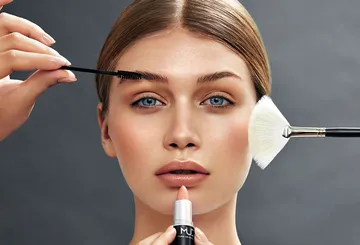 Frau erhält Make-up-Anwendung im Gesicht.