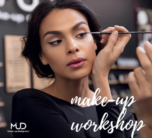 Frau trägt im Workshop Make-up mit Pinsel auf.