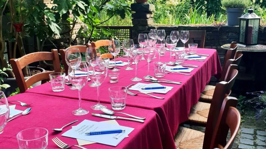 Tisch im Garten zum Essen gedeckt.