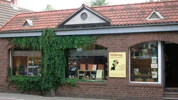 Backsteinhaus mit Weinladen und Efeu.