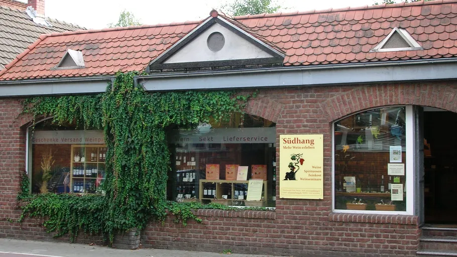 Brick wine shop with ivy and signs.