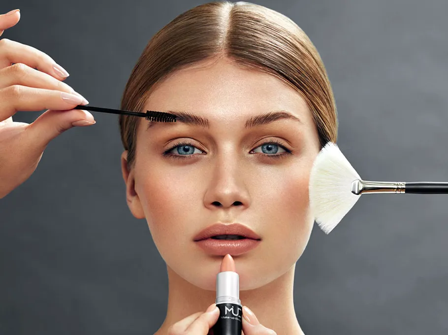 Frau erhält Make-up mit Pinsel und Mascara.