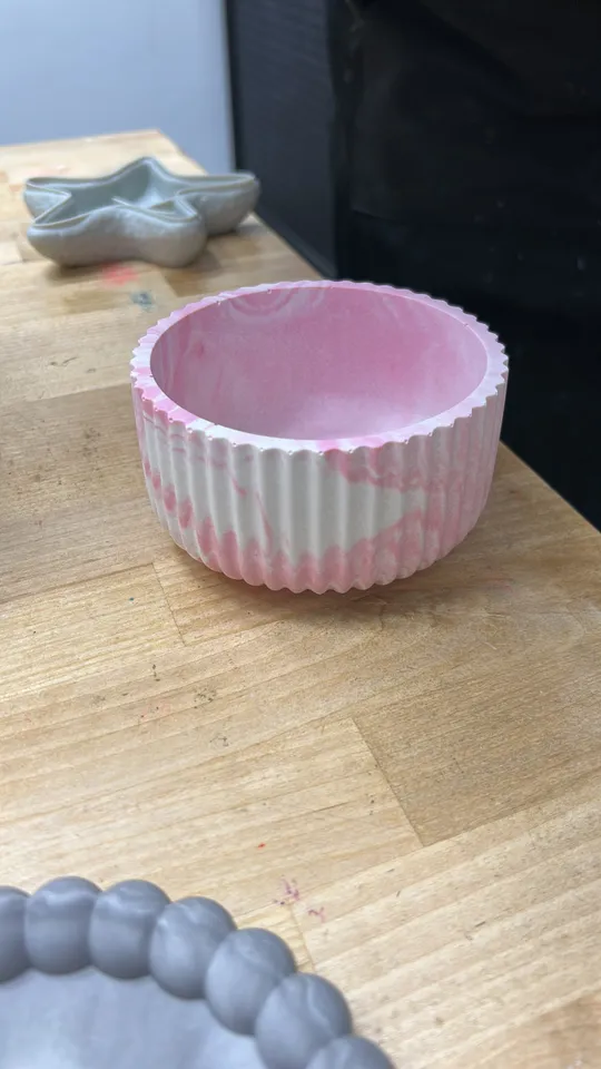 Rosa marmorierte Schale auf Holztisch.