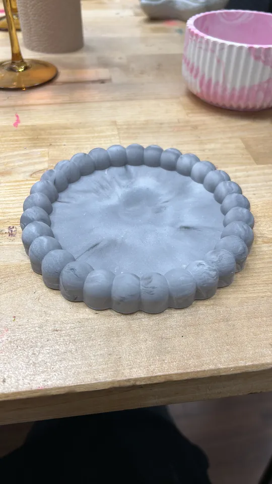 Tonplatte mit runder Kante auf Holztisch.