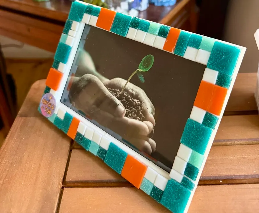 Colorful frame with plant photo on table.
