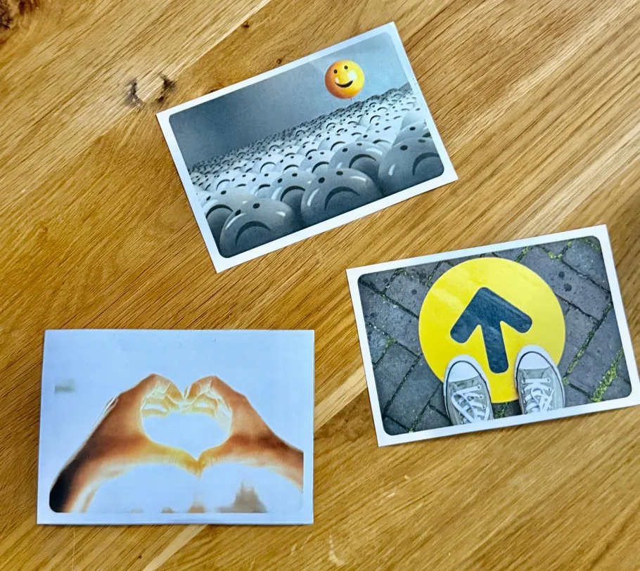 Three postcards on a wooden table.