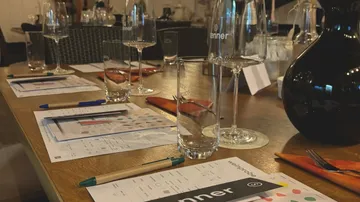 Weinprobe-Tisch mit Gläsern, Papieren und Stiften.