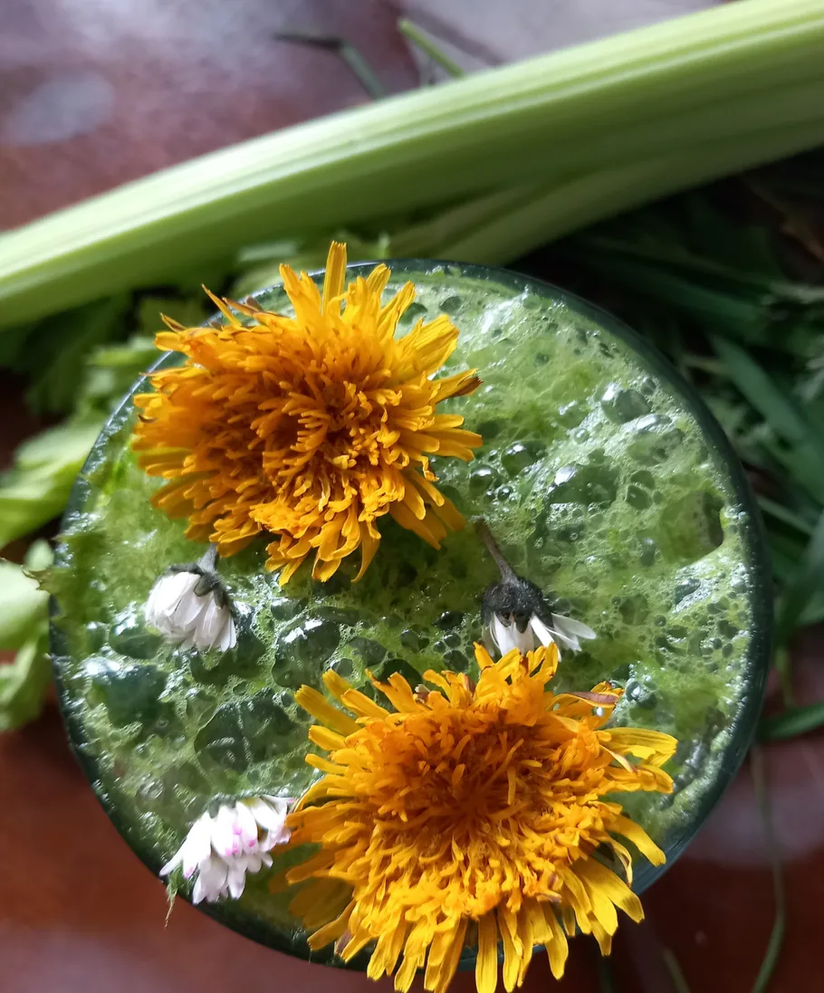 Grüner Smoothie mit Löwenzahnblüten obenauf.