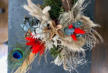 Colorful dried flower arrangement on dark surface.