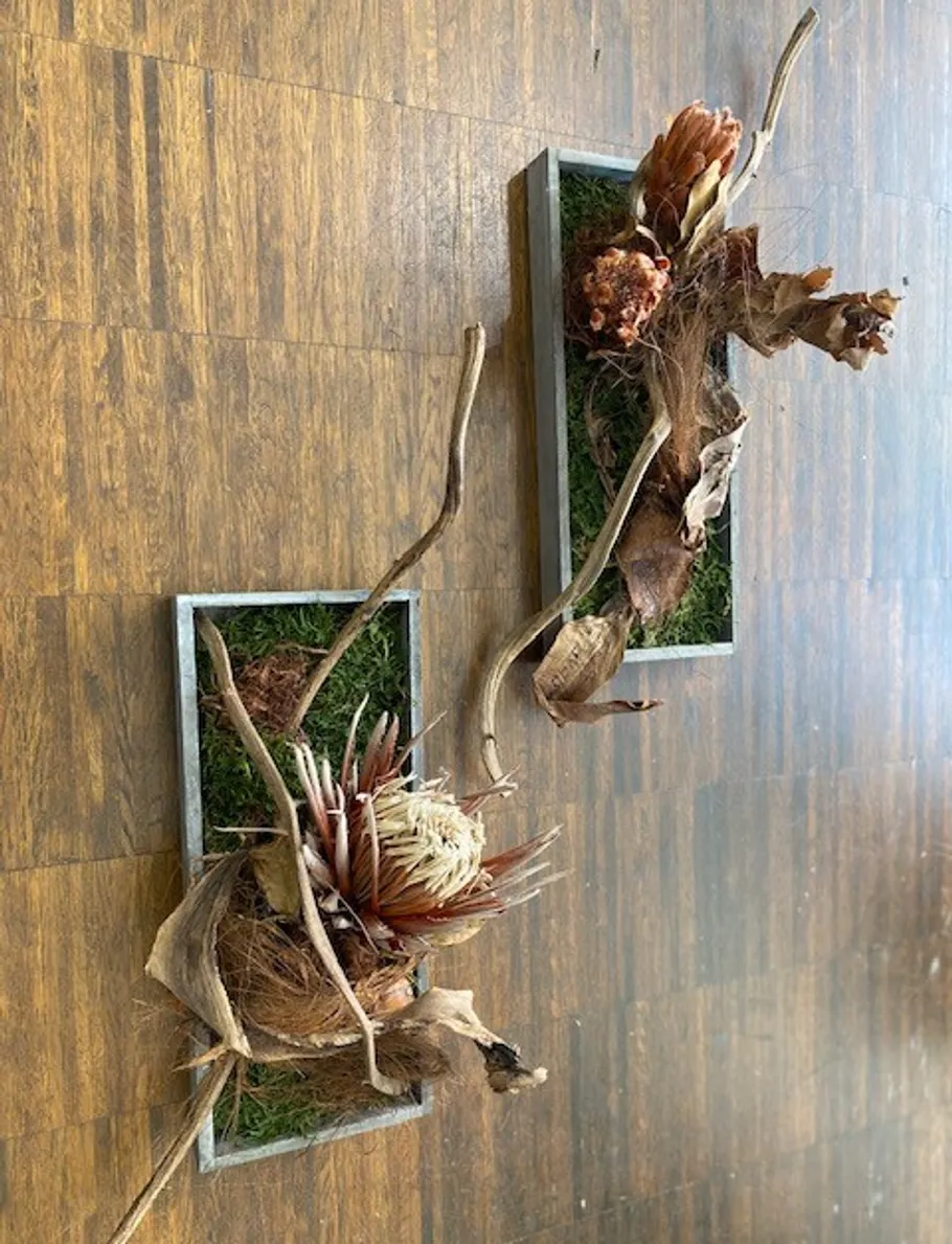 Floral arrangements on wooden floor.