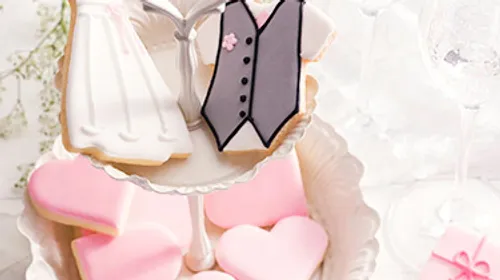 Wedding-themed cookies on cake stand.