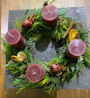 Adventskranz mit vier roten Kerzen im Innenraum.