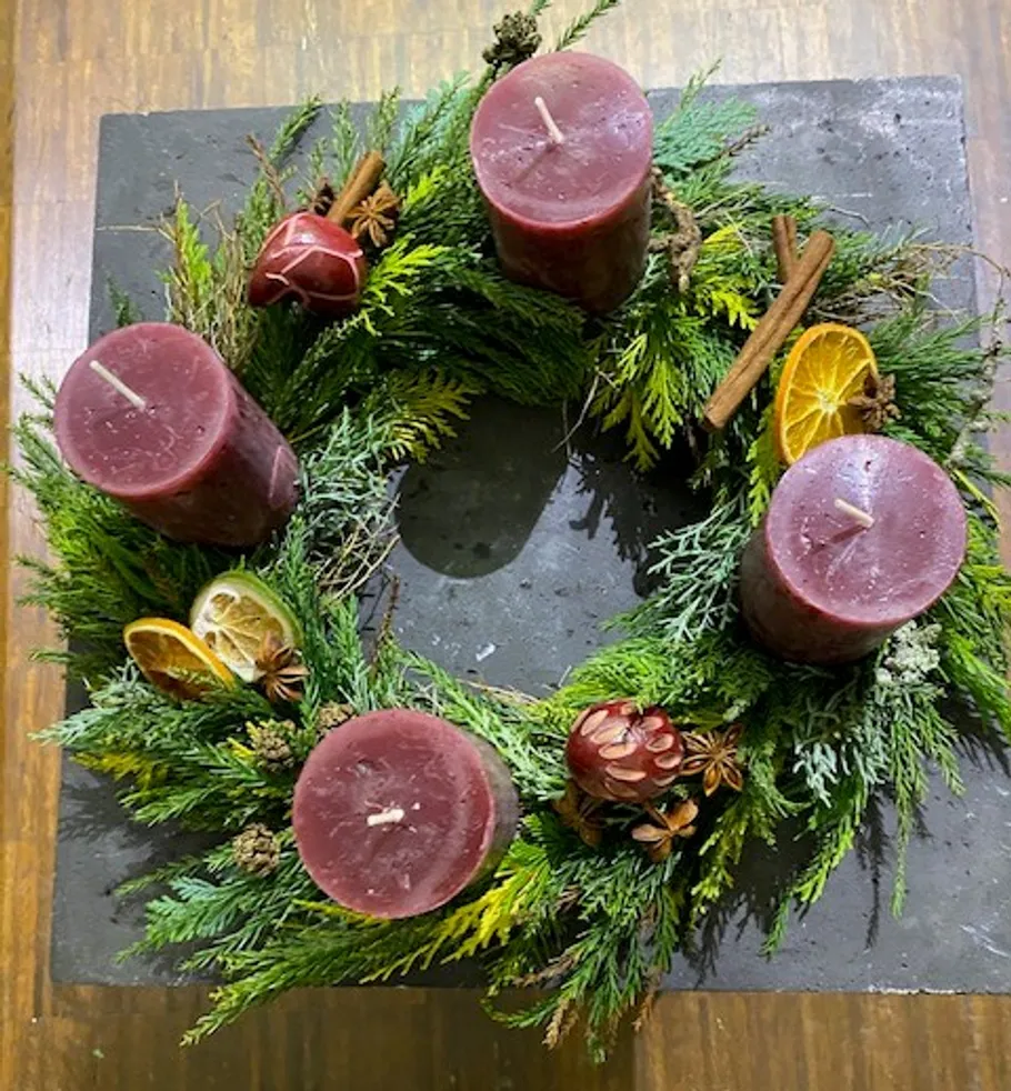 Advent wreath with four red candles indoors.