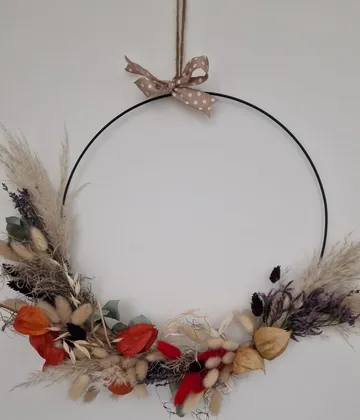 Floral wreath with autumn decorations on wall.