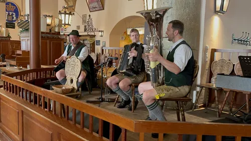 Musicians in traditional attire playing instruments indoors.