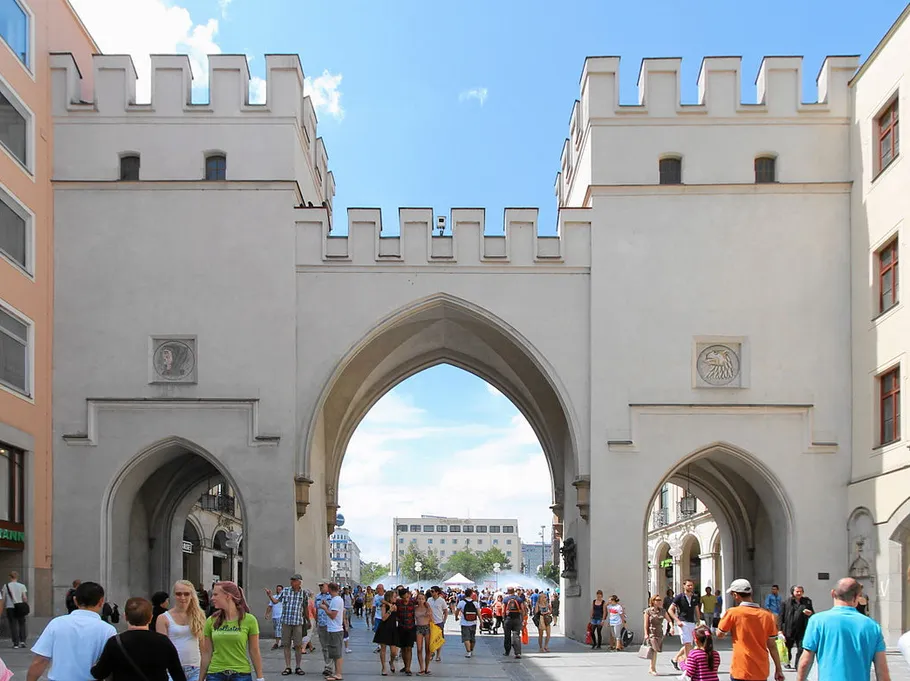 Crowded street with historic city gate.