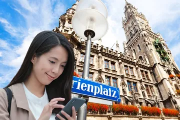 Woman using phone near historic building.