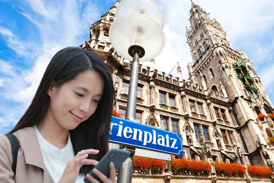 Woman using phone near historic building.