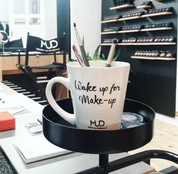 Tasse mit Pinseln in einem Make-up-Studio.