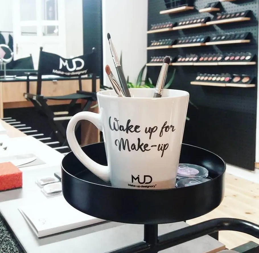 Mug with brushes in a makeup studio.