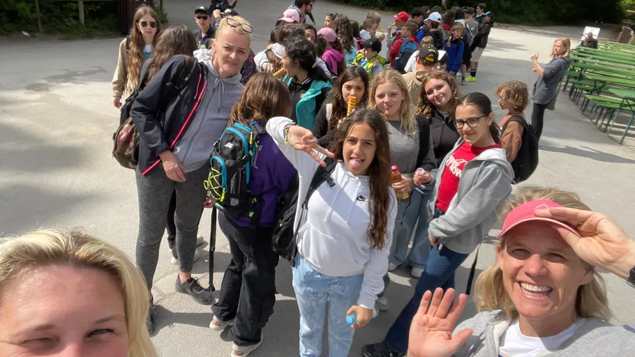 Gruppe von Menschen posiert draußen, lächelt zusammen.