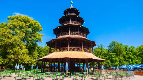 Wooden pagoda tower in leafy beer garden.