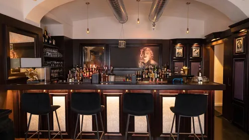 Elegant bar with stools and lit decor.