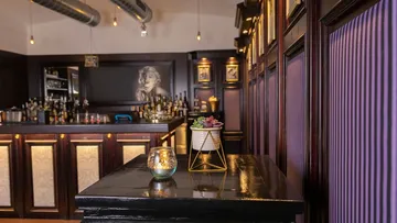 Elegantes Bar-Interieur mit lila Akzenten.