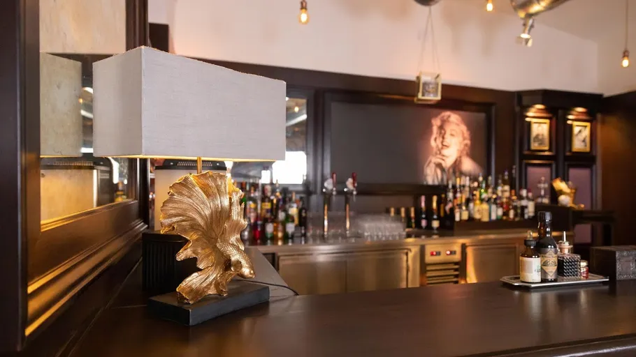 Goldene Lampe auf Theke, elegantes Bar-Umfeld.