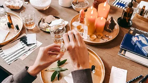 Hands preparing essential oils on a table.