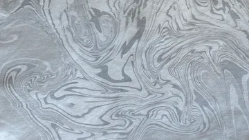 Wirbelndes abstraktes graues Muster auf Papier.